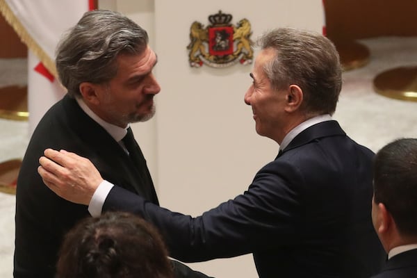 Georgian Dream party founder Bidzina Ivanishvili, right, embraces Georgian President-elect Mikheil Kavelashvili, left, at his swearing-in ceremony at the Georgian Parliament in Tbilisi, Georgia, Sunday, Dec. 29, 2024. (Irakli Gedenidze/Pool Photo via AP)