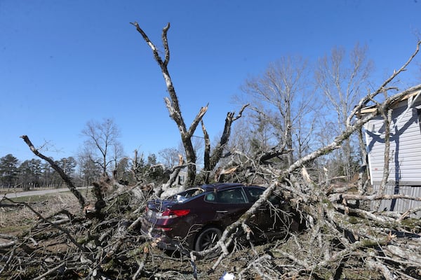 A car sits destroyed under the debris of a tree from severe weather along Lee County Rd 154 in Shannon, Miss. ,Monday, Feb. 17, 2025. (Thomas Wells/The Northeast Mississippi Daily Journal via AP)