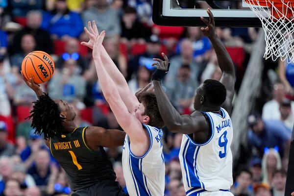 Baylor guard Robert Wright III shoots over Duke guard Caleb Foster (1) and center Khaman Maluach (9) during the first half in the second round of the NCAA college basketball tournament, Sunday, March 23, 2025, in Raleigh, N.C. (AP Photo/Chris Carlson)