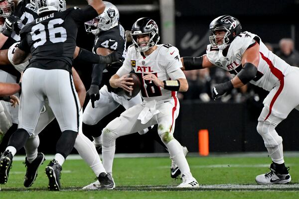 Atlanta Falcons quarterback Kirk Cousins (18) is pressured by Las Vegas Raiders defensive end K'Lavon Chaisson (44) during the first half of an NFL football game, Monday, Dec. 16, 2024, in Las Vegas. (AP Photo/David Becker)