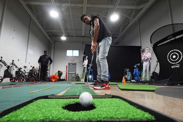 Jacento White, 16, a junior golfer at Renaissance High School practices putting in Detroit, Thursday, Feb. 27, 2025. (AP Photo/Paul Sancya)
