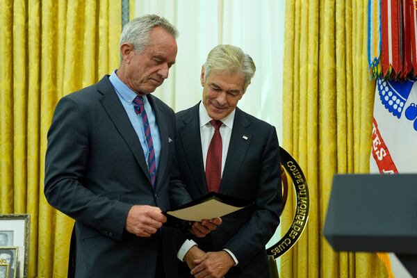 Health and Human Services Secretary Robert F. Kennedy Jr., left, and Dr. Mehmet Oz attend a swearing in ceremony for Oz to be Administrator of the Centers for Medicare and Medicaid Services, in the Oval Office of the White House, Friday, April 18, 2025, in Washington. (AP Photo/Alex Brandon)