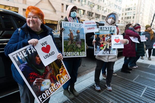 Retired United States Agency for International Development worker Julie Hanson Swanson, left, join supporters of USAID workers outside the USAID's Bureau of Humanitarian affairs office in Washington, Friday, Feb. 21, 2025. (AP Photo/Manuel Balce Ceneta)