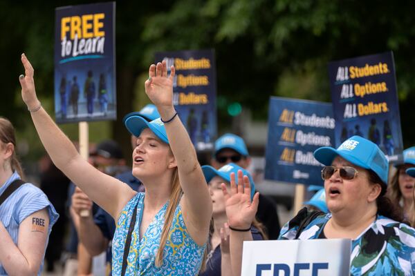 Pamela Smith of Sterling, Va., left, and Tammy-Kay Williams of Fountain Hills, Ariz., right, react as supporters of charter schools rally outside of the Supreme Court on Wednesday, April 30, 2025, in Washington. (AP Photo/Mark Schiefelbein)