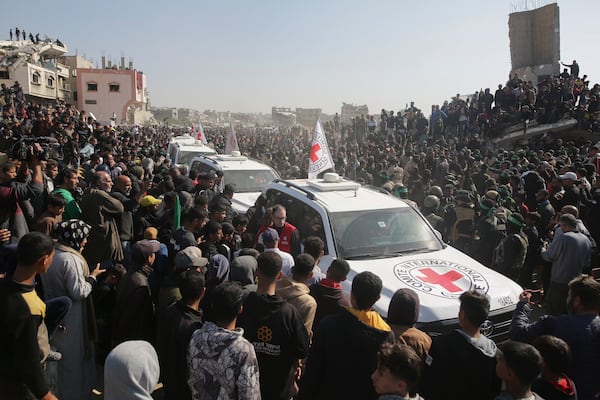 A crowd surrounds Red Cross cars as they arrive at the site for the handover of Thai and Israeli hostages in Khan Younis, southern Gaza Strip, Thursday Jan. 30, 2025.(AP Photo/Jehad Alshrafi)