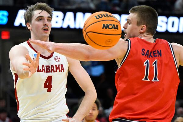 Alabama forward Grant Nelson (4) throws a pass beside Saint Mary's center Mitchell Saxen (11) in the second half in the second round of the NCAA college basketball tournament, Sunday, March 23, 2025, in Cleveland. (AP Photo/David Richard)