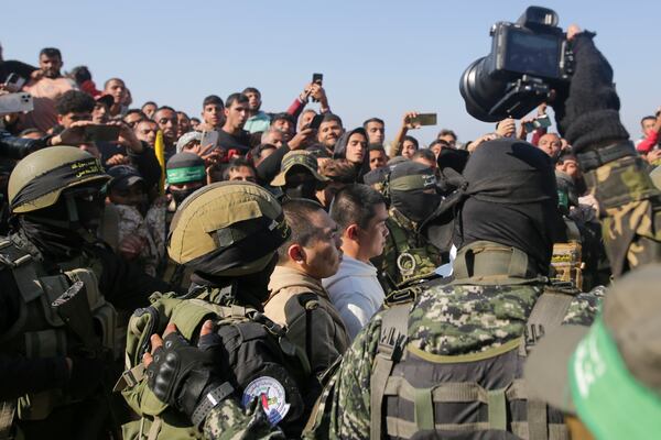 Two Thai captives, who has been held hostage by Hamas in Gaza since October 7, 2023, are escorted by Hamas fighters as they are handed over to the Red Cross in Khan Younis, southern Gaza Strip, Thursday Jan. 30, 2025.(AP Photo/Jehad Alshrafi)