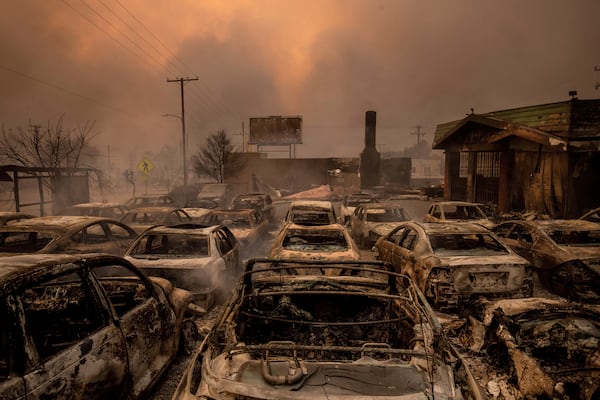 Fire-damaged vehicles are lined up at a dealership after the Eaton Fire swept through Wednesday, Jan. 8, 2025 in Altadena, Calif. (AP Photo/Ethan Swope)