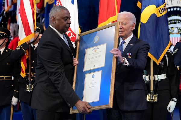 Defense Secretary Lloyd Austin, left, presents a plaque to President Joe Biden for the medal for Distinguished Public Service during a Department of Defense Commander in Chief farewell ceremony at Joint Base Myer-Henderson Hall, Thursday, Jan. 16, 2025, in Arlington, Va. (AP Photo/Evan Vucci)