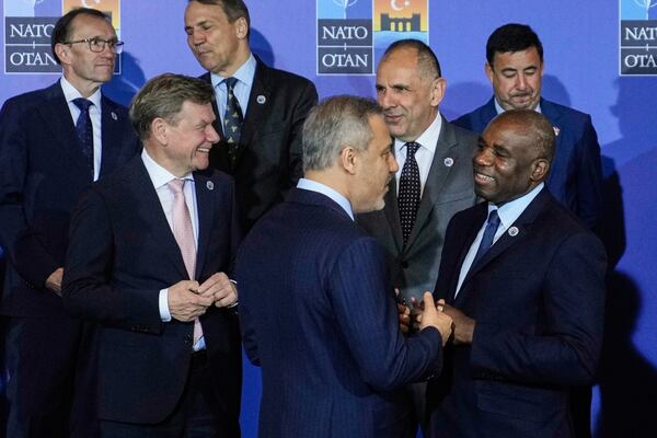 Turkey's Foreign Minister Hakan Fidan, center, talks to British Foreign Secretary David Lammy, right, next to Germany's Foreign Minister Johann Wadephul, left, as they wait for a group photo during a NATO's informal meeting of foreign ministers in Antalya, southern Turkey, Thursday, May 15, 2025. (AP Photo/Khalil Hamra)
