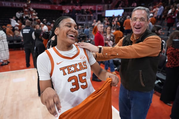 Texas forward Madison Booker (35) celebrates with Texas athletic director Chris Del Conte, right, after the team's win over South Carolina in an NCAA college basketball game in Austin, Texas, Sunday, Feb. 9, 2025. (AP Photo/Eric Gay)