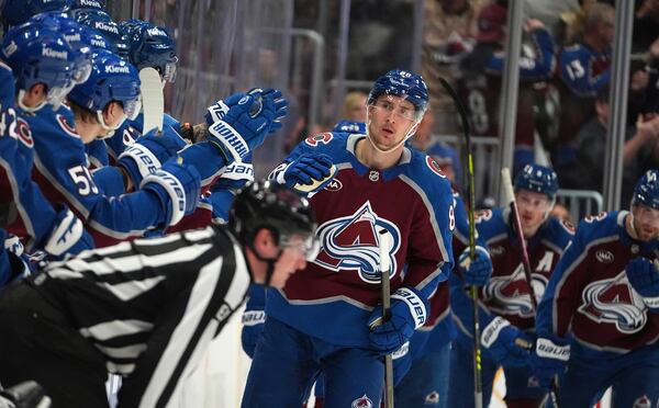 Colorado Avalanche center Martin Necas, center, is congratulated as he passes the team box after scoring in the second period of Game 6 of an NHL hockey first-round playoff series against the Colorado Avalanche, Thursday, May 1, 2025, in Denver. (AP Photo/David Zalubowski)