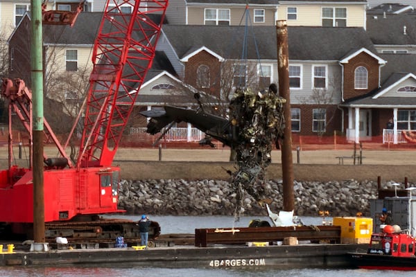 Rescue and salvage crews pull up a part of a Army Black Hawk helicopter that collided midair with an American Airlines jet, at a wreckage site in the Potomac River from Ronald Reagan Washington National Airport, Thursday, Feb. 6, 2025, in Arlington, Va. (AP Photo/Jose Luis Magana)