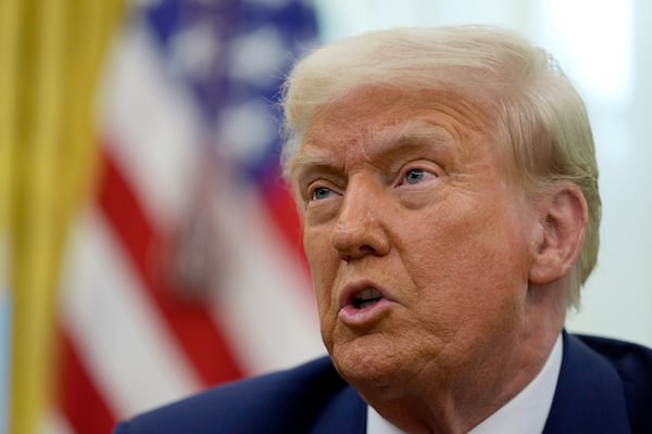 President Donald Trump speaks to reporters after signing an executive order in the Oval Office of the White House, Thursday, Feb. 13, 2025, in Washington. (AP Photo/Ben Curtis)