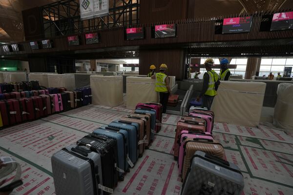 Airport staff members test the luggage machine inside an under construction of a new airport of Techo International Airport at the outskirts of Phnom Penh Cambodia, Friday, March 21, 2025. (AP Photo/Heng Sinith)