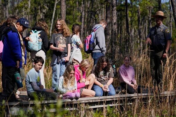Park ranger Jesse Anderson, right, speaks to visitors during a weekly carnivorous plant hike Saturday, March 22, 2025, in Carolina Beach, N.C. (AP Photo/Erik Verduzco)