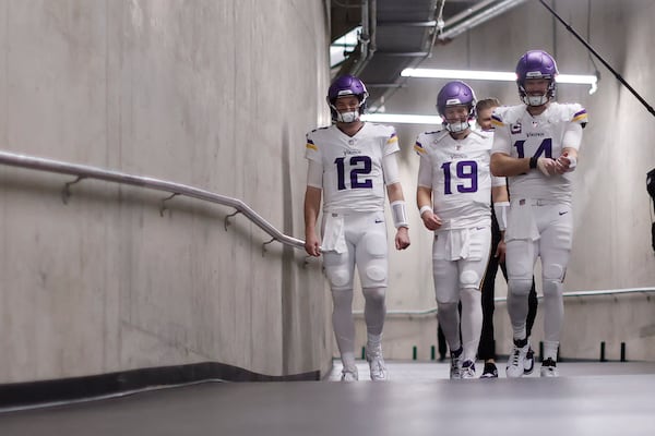 Minnesota Vikings quarterbacks Nick Mullens (12), Brett Rypien (19) and Sam Darnold (14) walk to the field before an NFL football game against the Detroit Lions, Sunday, Jan. 5, 2025, in Detroit. (AP Photo/Rey Del Rio)