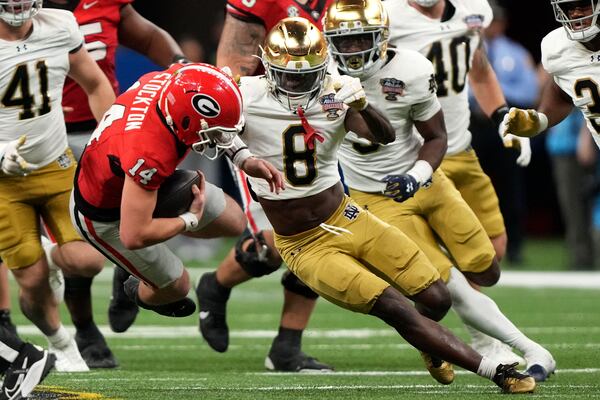 Georgia quarterback Gunner Stockton (14) is tackled by Notre Dame safety Adon Shuler (8) during the second half in the quarterfinals of a College Football Playoff, Thursday, Jan. 2, 2025, in New Orleans. (AP Photo/Gerald Herbert)