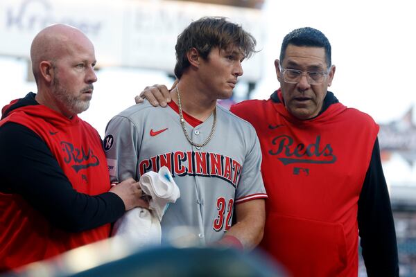 Cincinnati Reds outfielder Tyler Callihan (32) is helped off the field after colliding with the wall during the third inning of a baseball game against the Atlanta Braves, Monday, May 5, 2025, in Atlanta. (AP Photo/Butch Dill)