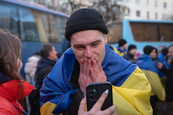 A Ukrainian serviceman speaks on phone with his relatives after returning from captivity during a POWs exchange between Russia and Ukraine in Ukraine, Wednesday, March 19, 2025. (AP Photo/Efrem Lukatsky)