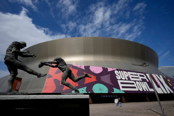 People walk outside the Caesars Superdome, Friday, Jan. 31, 2025, in New Orleans prior to the NFL Super Bowl 59 football game between the Philadelphia Eagles and the Kansas City Chiefs. (AP Photo/Matt York)