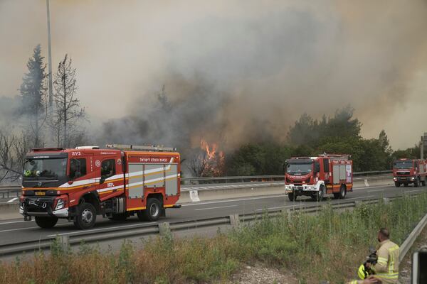 Firefighters work to extinguish a forest fire burning on a freeway to Jerusalem, Wednesday, April 30, 2025. (AP Photo/Mahmoud Illean)