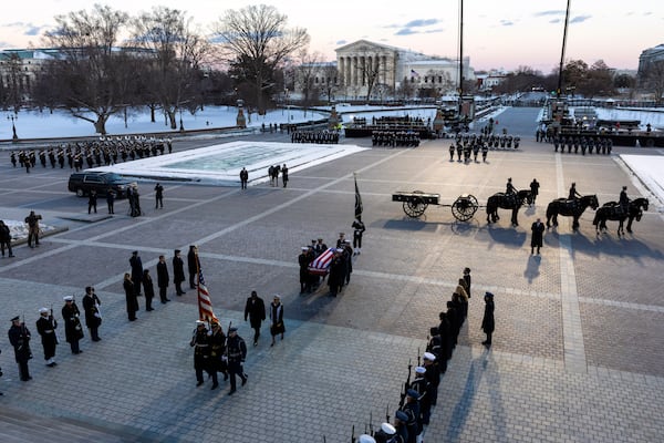 A joint services body bearer team moves the casket of former President Jimmy Carter after it arrived on a horse-drawn caisson at the East Front of U.S. Capitol in Washington, Tuesday, Jan. 7, 2025. (Shawn Thew/Pool via AP)