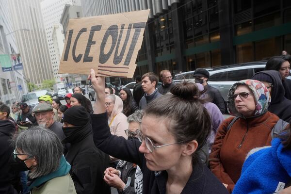 A person holds up a sign during a news conference and rally by immigrant justice organizations and advocates protesting ICE arrests in San Francisco, Wednesday, May 28, 2025. (AP Photo/Jeff Chiu)