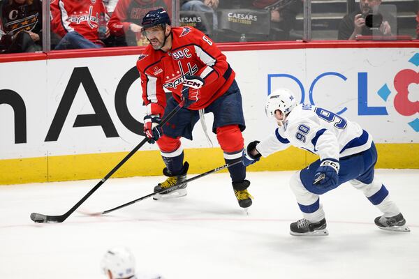 Washington Capitals left wing Alex Ovechkin (8) looks to pass against Tampa Bay Lightning defenseman J.J. Moser (90) during the third period of an NHL hockey game, Saturday, March 1, 2025, in Washington. (AP Photo/Nick Wass)