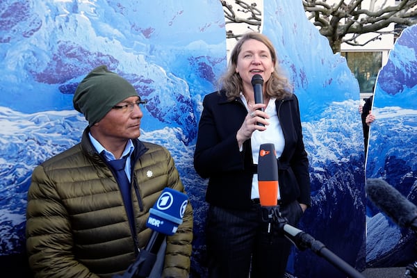 Peruvian farmer Luciano Lliuya, left, listens to lawyer Roda Verheyen at the Higher Regional Court in Hamm, Germany, before a first hearing of his climate damages case against the German energy company RWE for its carbon emissions, which may have been contributing to the melting of a nearby glacier that could flood his home, Monday, March 17, 2025. (AP Photo/Martin Meissner)