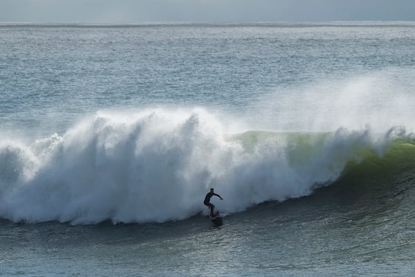 A surfer rides a large wave at Steamer Lane in Santa Cruz, Calif., Tuesday, Dec. 24, 2024. (AP Photo/Nic Coury)