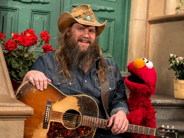 This image released by Sesame Workshop shows singer-songwriter Chris Stapleton, left, with muppet character Elmo on the set of "Sesame Street." (Zach Hyman/Sesame Workshop via AP)