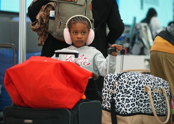 Young traveller queues up at a United Airlines self-check kiosk in Denver International Airport Tuesday, Dec. 24, 2024, in Denver. (AP Photo/David Zalubowski)