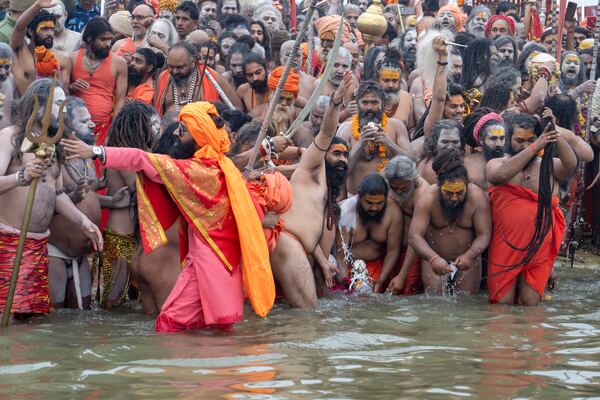 Hindu ascetics and holy men immerse an idol before bathing at the confluence of the Ganges, the Yamuna and the mythical Saraswati rivers on the second day of the 45-day-long Maha Kumbh festival in Prayagraj, India, Tuesday, Jan. 14, 2025. (AP Photo/Ashwini Bhatia)