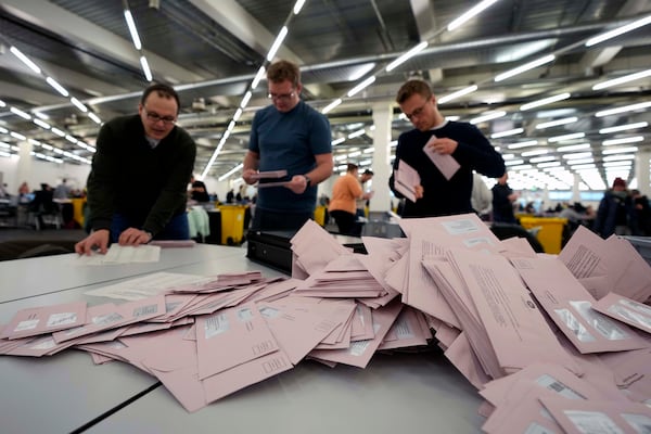 Volunteers prepare postal votes during the German national election in Munich, Germany, Sunday, Feb. 23, 2025. (AP Photo/Matthias Schrader)