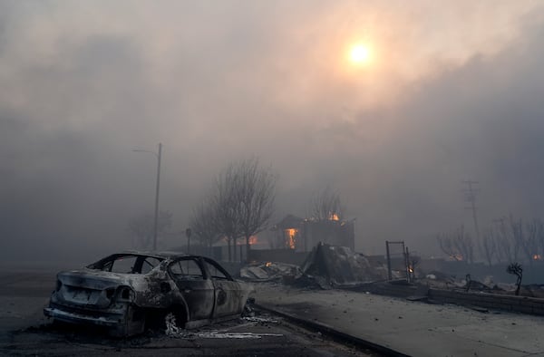 A burned-out car sits among rubble, Wednesday, Jan. 8, 2025, in the downtown Altadena section of Pasadena, Calif. (AP Photo/Chris Pizzello)