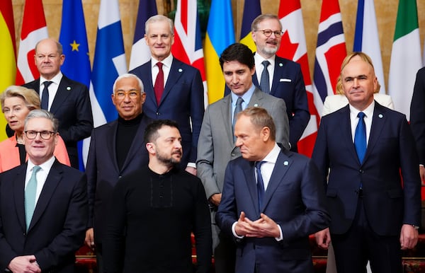 Canada Prime Minister Justin Trudeau, second row, looks towards Ukraine's President Volodymyr Zelenskyy as he talks to Polish Prime Minister Donald Tusk, bottom right, as they take part in a family photo during the Securing our Future Summit on Ukraine and European security at Lancaster House in London, Sunday, March 2, 2025. (Sean Kilpatrick/The Canadian Press via AP)