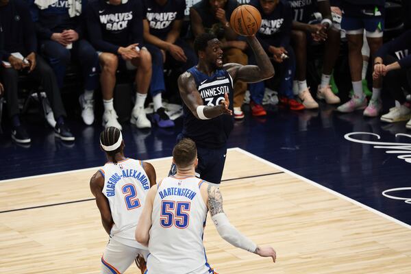 Minnesota Timberwolves forward Julius Randle (30) shoots against Oklahoma City Thunder guard Shai Gilgeous-Alexander (2) and center Isaiah Hartenstein (55) during the second half of Game 3 of the Western Conference finals of the NBA basketball playoffs, Saturday, May 24, 2025, in Minneapolis. (AP Photo/Matt Krohn)