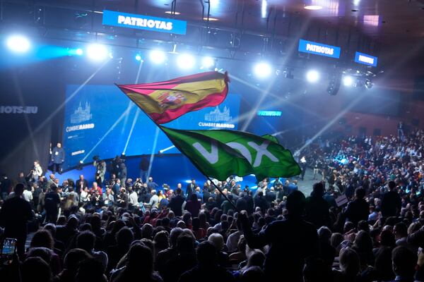 FILE - A Spanish flag and a Spanish far-right VOX party flag are waved during the far-right Patriots for Europe summit in Madrid, Spain, Feb. 8, 2025. (AP Photo/Paul White, file)