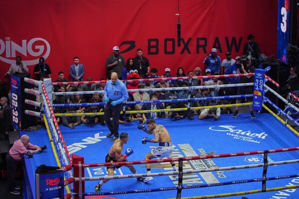 Teofimo Lopez, left, fights Arnold Barboza Jr. during a super lightweight boxing match in Times Square Friday, May 2, 2025, in New York. (AP Photo/Frank Franklin II)