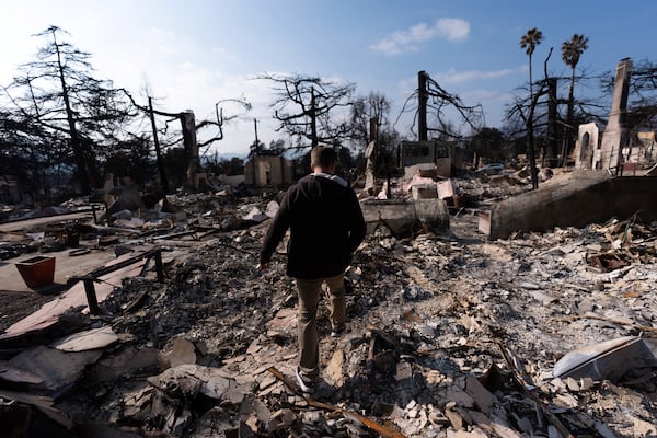 FILE - Chris Wilson walks through the remains of his home, consumed by the Eaton Fire, in Altadena, Calif., Thursday, Jan. 30, 2025. (AP Photo/Jae C. Hong, File )