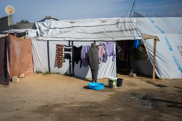 A woman hangs her laundry outside a tent at a camp for displaced Palestinians in Deir al-Balah, central Gaza Strip, Friday Jan. 17, 2025. (AP Photo/Abdel Kareem Hana)