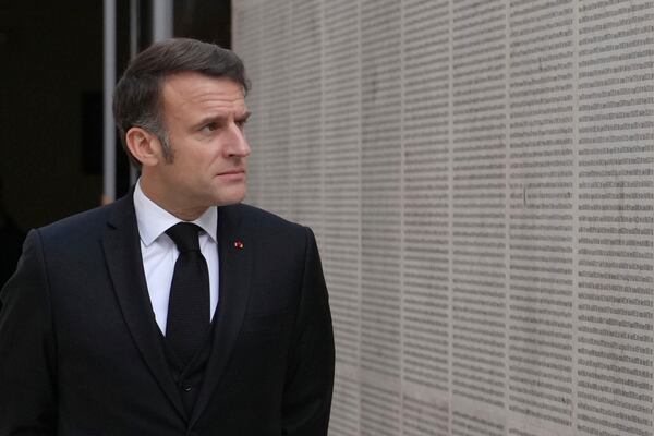 French President Emmanuel Macron walks past the wall of names during ceremonies marking the 80th anniversary of the liberation of the Nazi death camp of Auschwitz-Birkenau, at the Paris Holocaust Memorial, Monday, Jan. 27, 2025 in Paris. (AP Photo/Thibault Camus, Pool)