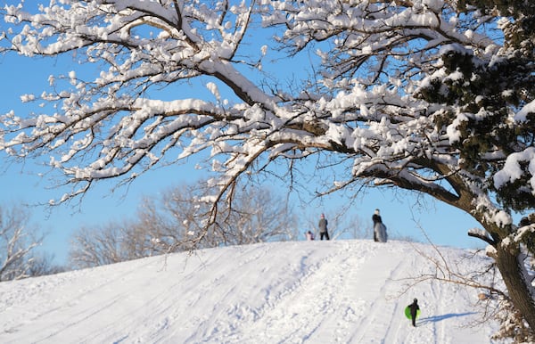 Early morning sledders enjoy the hill at Sedgwick County Park in Wichita, Kan. on Friday, Jan. 10, 2025. (Jaime Green/The Wichita Eagle via AP)