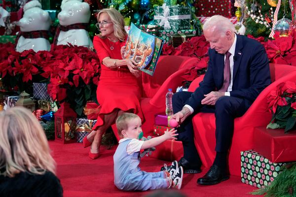 President Joe Biden and first lady Jill Biden, as she reads 'Twas the Night Before Christmas, visit patients and families at the Children's National Hospital in Washington, Friday, Dec. 20, 2024. (AP Photo/Ben Curtis)