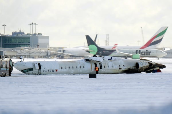 A Delta Air Lines plane lies upside down at Toronto Pearson Airport on Tuesday, Feb. 18, 2025. (Chris Young/The Canadian Press via AP)