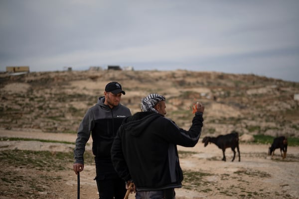 Salem Adra, left, brother of Palestinian activist Basel Adra, who won Best Documentary Feature at the Oscars for "No Other Land" talks with a local Palestinian shepherd as they stand near an Israeli settlers' outpost at the West Bank village of Tuwani, Monday, March 3, 2025. (AP Photo/Leo Correa)