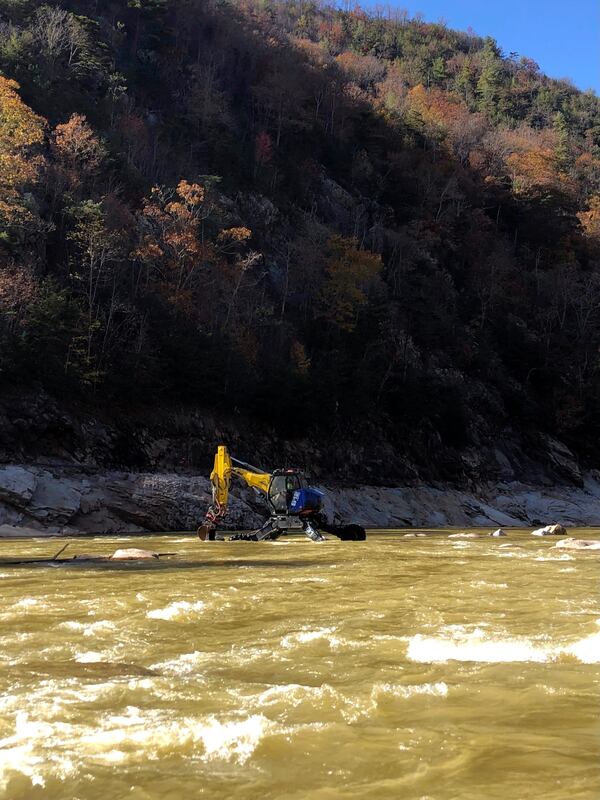 This photo provided by Patrick Mannion shows heavy equipment in the Nolichucky River gorge, between Poplar, N.C., and Erwin, Tenn., on Oct. 30, 2024, where flooding from September’s Hurricane Helene devastated this mountainous region on the Tennessee-North Carolina border. (Patrick Mannion via AP)