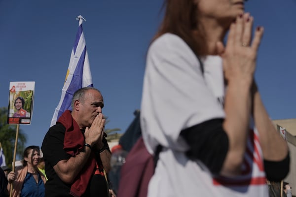 Israelis react as they watch a broadcast of the release of American-Israeli Keith Siegel, as he is released as part of a ceasefire in the Gaza Strip, in Tel Aviv, Israel, Saturday Feb. 1, 2025. (AP Photo/Oded Balilty)