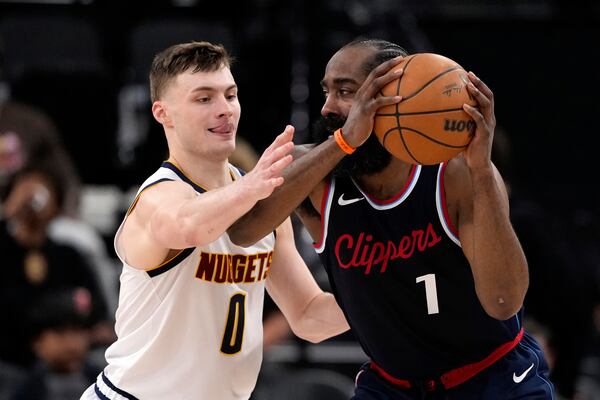 Los Angeles Clippers guard James Harden, right, tries to pass while under pressure from Denver Nuggets guard Christian Braun during the second half in Game 6 of an NBA basketball first-round playoff series Thursday, May 1, 2025, in Inglewood, Calif. (AP Photo/Mark J. Terrill)